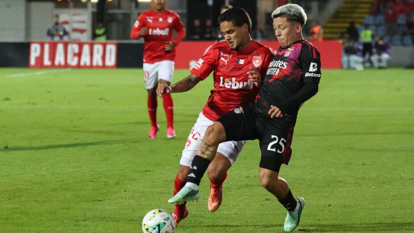 Gianluca Prestianni, del Benfica, disputa la pelota cuerpo a cuerpo con un jugador del Santa Clara, de camiseta roja (foto: SL Benfica)
