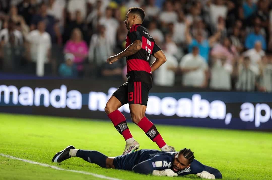 Danilo, con la camiseta rojinegra del Flamengo, se va a festejar el 1-0 mientras el arquero Diógenes queda tendido en el pasto de Vila Belmiro (foto: Gilvan de Souza / CRF)