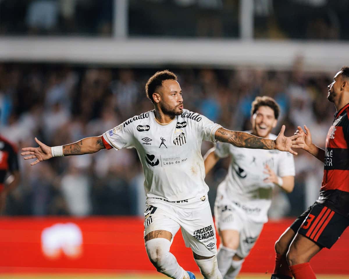 Neymar festeja con los brazos abiertos uno de sus goles de penal ante Flamengo en Vila Belmiro, con la camiseta blanca del Santos (foto: Raul Baretta / Santos FC)