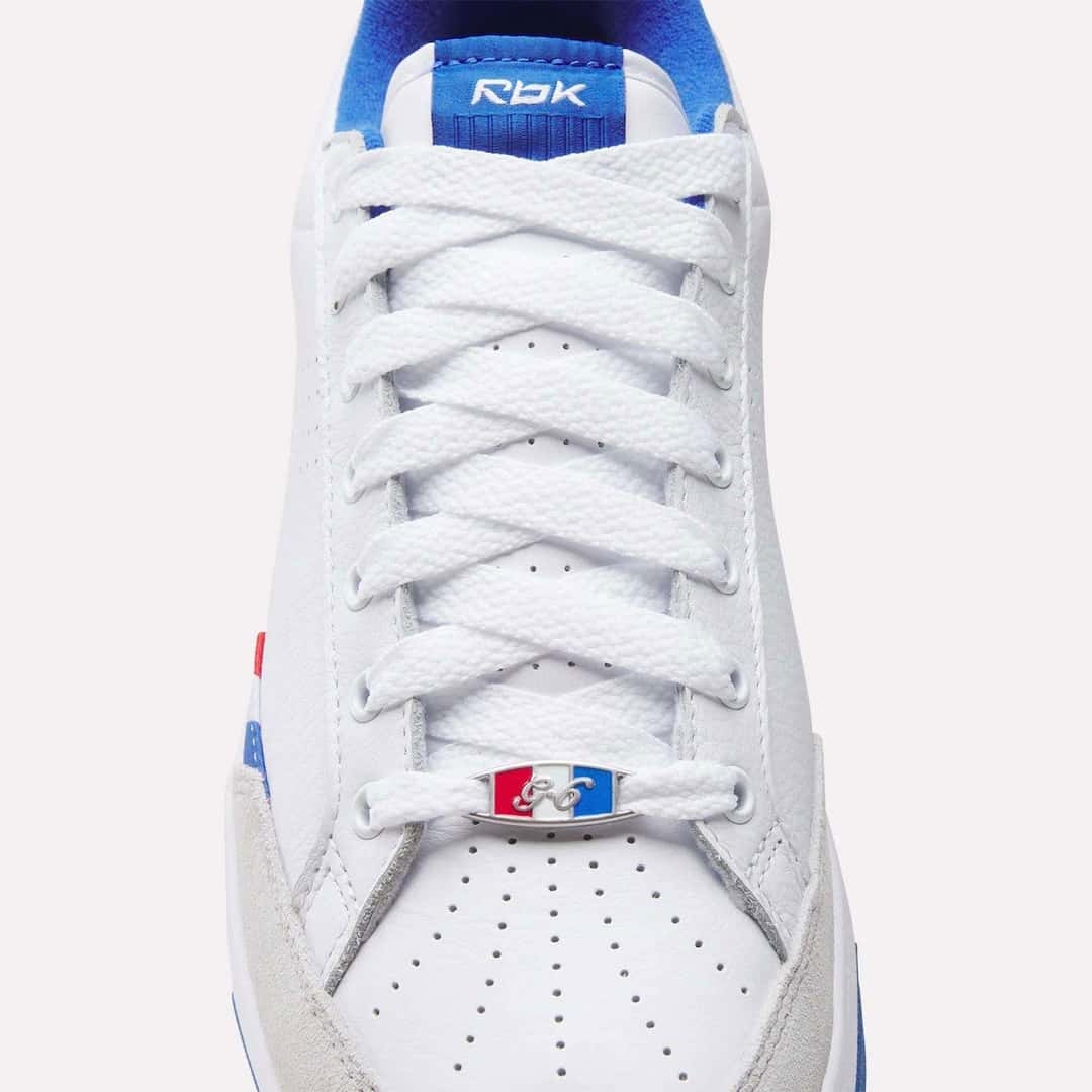 Detalle de los cordones blancos de la Reebok G-Unit G6, con la placa roja, blanca y azul sobre la puntera perforada y el logo Rbk en la lengüeta