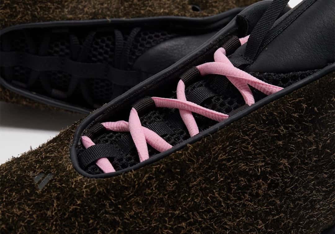 Detalle del sistema de cordones de la Guadalupe x adidas Intimidation, con cordones rosa sobre la malla negra interna y la gamuza de pelo largo alrededor