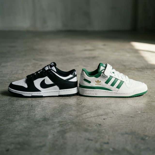 Nike Dunk Low negra junto a Adidas Forum Low verde sobre superficie de concreto
