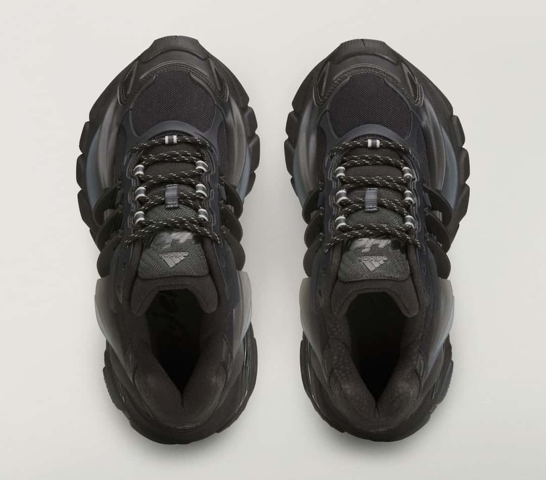 Vista desde arriba de un par de Pharrell x adidas Adistar Jellyfish Triple Black, con los ojales metálicos y los cordones negros
