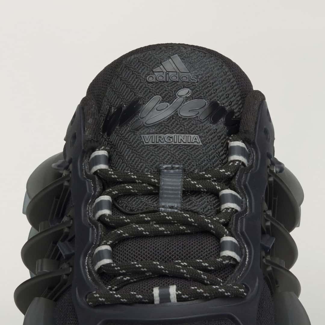 Detalle de la lengüeta de la Pharrell x adidas Adistar Jellyfish Triple Black, con el logo de adidas, la palabra Virginia en relieve y los cordones negros con hilos reflectivos
