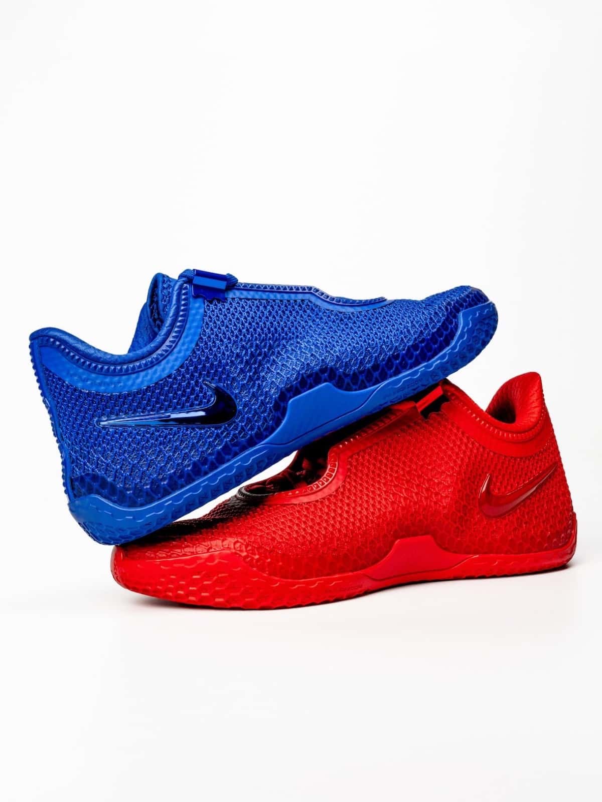 Nike LeBron 24 Philly azul apoyada sobre otra roja, con capellada tejida con relieve y Swoosh brillante, sobre fondo blanco