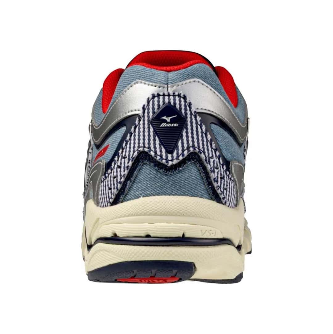 Talón de la Mizuno Wave MG4 LS de Sean Wotherspoon, con el logo de Mizuno, el jean a rayas, el forro rojo y la suela crema