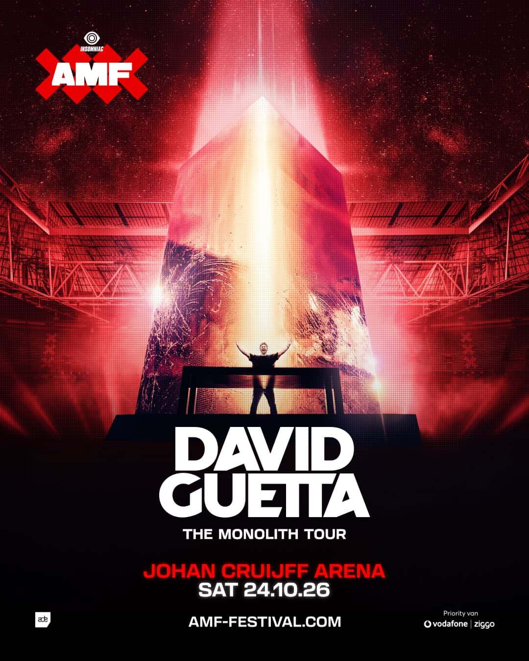 Afiche oficial del AMF 2026: David Guetta, de espaldas y con los brazos abiertos, frente a un gigantesco monolito iluminado en un estadio teñido de rojo, con el texto David Guetta, The Monolith Tour, Johan Cruijff Arena, sábado 24.10.26