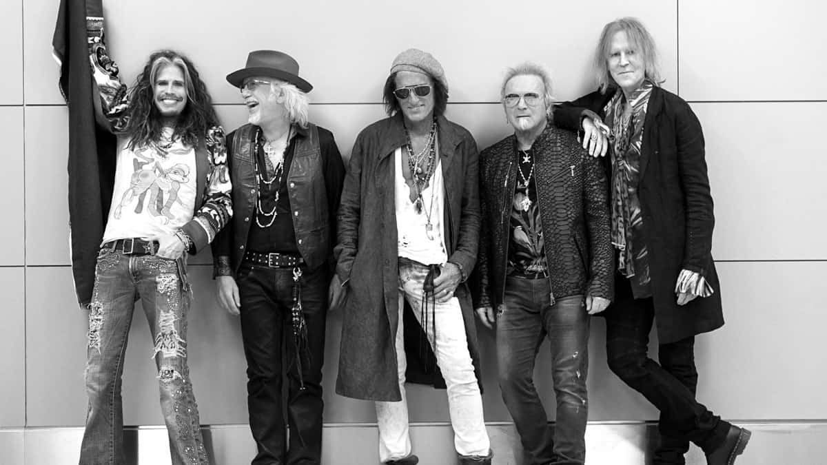 Foto de prensa oficial de Aerosmith (foto de archivo, de Ross Halfin, difundida con el anuncio): los cinco integrantes de la banda apoyados contra una pared clara, en blanco y negro