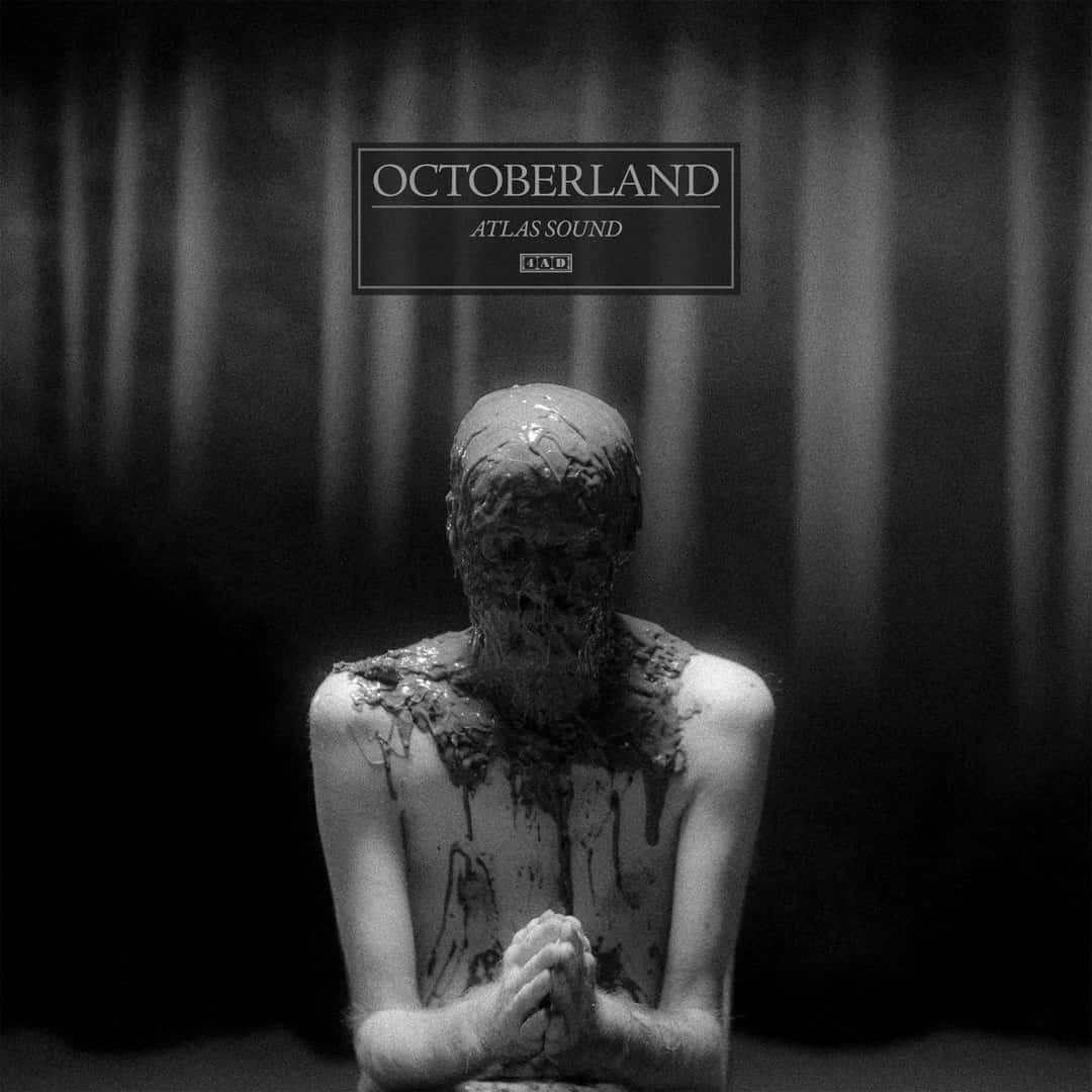 Portada de «Octoberland», de Atlas Sound: en blanco y negro, una figura sentada con las manos juntas y la cabeza cubierta de papel maché, frente a un telón oscuro