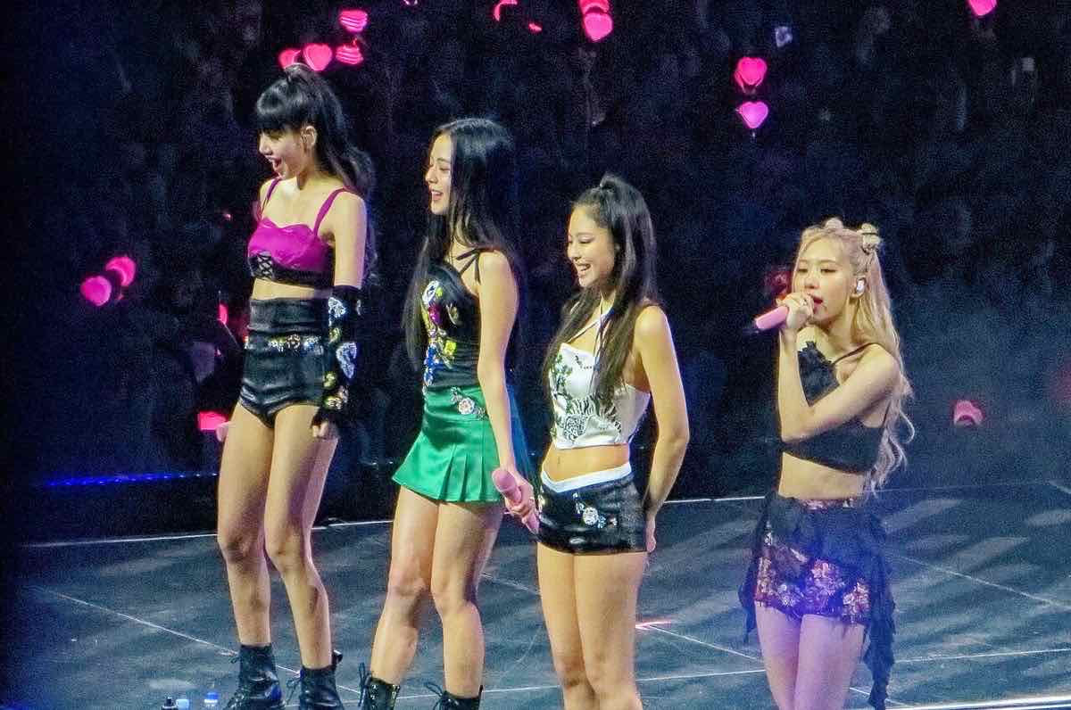 Foto de archivo de BLACKPINK en el O2 Arena de Londres durante la gira «Born Pink», en diciembre de 2022: Lisa, Jisoo y Jennie sonríen mientras Rosé habla con el público con un micrófono rosa