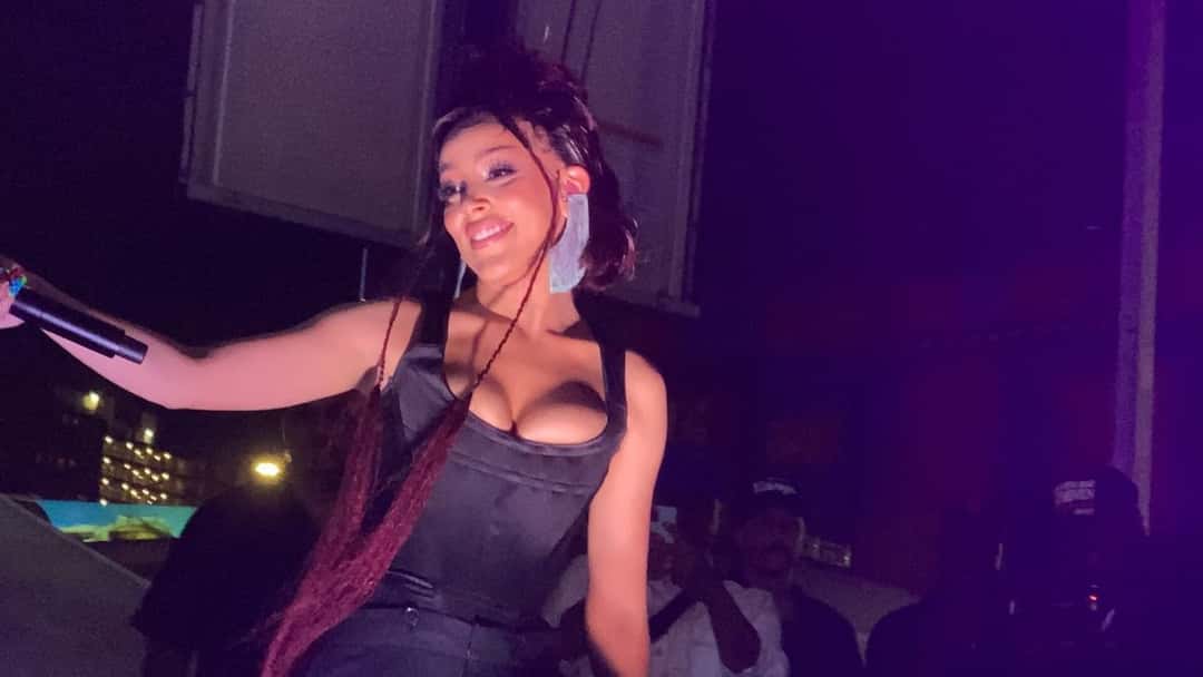 Doja Cat canta con un corset negro y trenzas rojas, micrófono en mano, en un show en Coney Island, Nueva York, en 2021 (foto de archivo). Foto: Naz, CC BY-SA 4.0, vía Wikimedia Commons