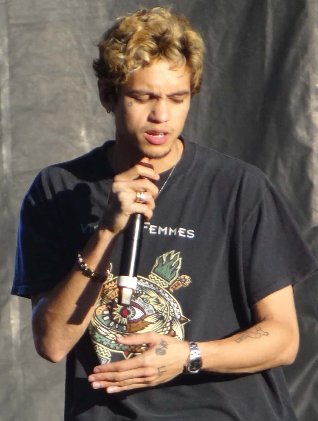 Dominic Fike canta con el micrófono en la mano y una remera negra estampada, durante un show en el festival Shaky Knees de 2021 (foto de archivo)