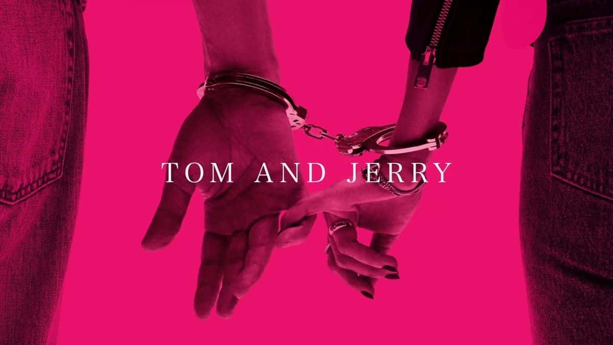 Arte oficial de «Tom and Jerry», de John Mayer: dos manos esposadas, una con campera de cuero y la otra con anillos, sobre un fondo fucsia, con el título en letras blancas