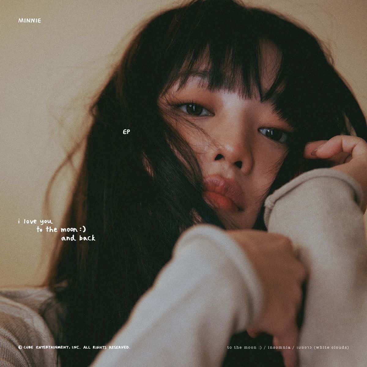 Portada de «i love you to the moon and back»: MINNIE, con flequillo y pelo castaño despeinado, mira a cámara con la cara apoyada en las manos, sobre un fondo color crema