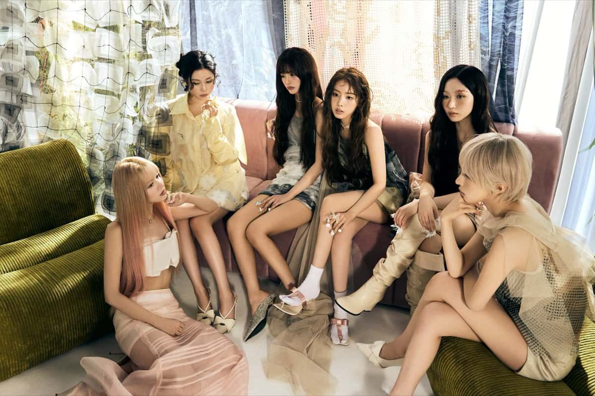 Foto conceptual oficial de NMIXX para "Strange Muse" (versión Muse): las seis integrantes en un living con sillones verdes y un sofá rosa, frente a cortinas de encaje y tela estampada
