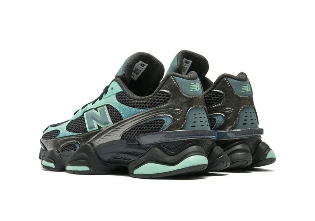 Par de New Balance 9060 Deep End/Black Metallic visto de atrás en diagonal, con la malla negra, los paneles verde agua y la suela negra