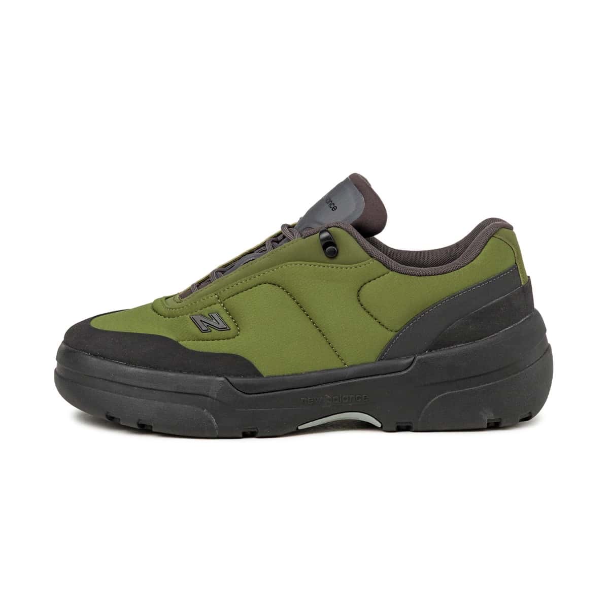 New Balance TL900 Sport Green/Black de perfil sobre fondo blanco, con upper acolchado verde oliva, logo N chico, puntera y talón negros y suela de goma negra con tacos