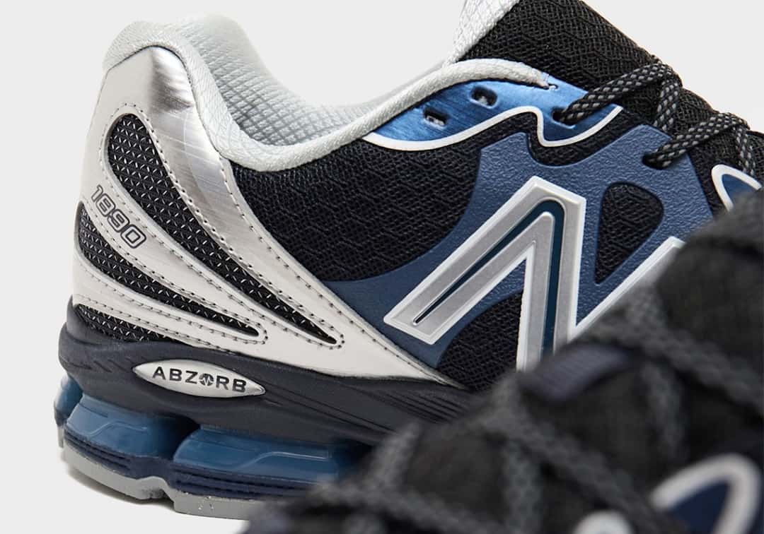 Detalle del talón y el lateral del New Balance 1890 Metallic Blue, con el panel plateado cepillado, el número 1890, la placa ABZORB, la N plateada sobre el panel azul y las cápsulas azules translúcidas de la mediasuela