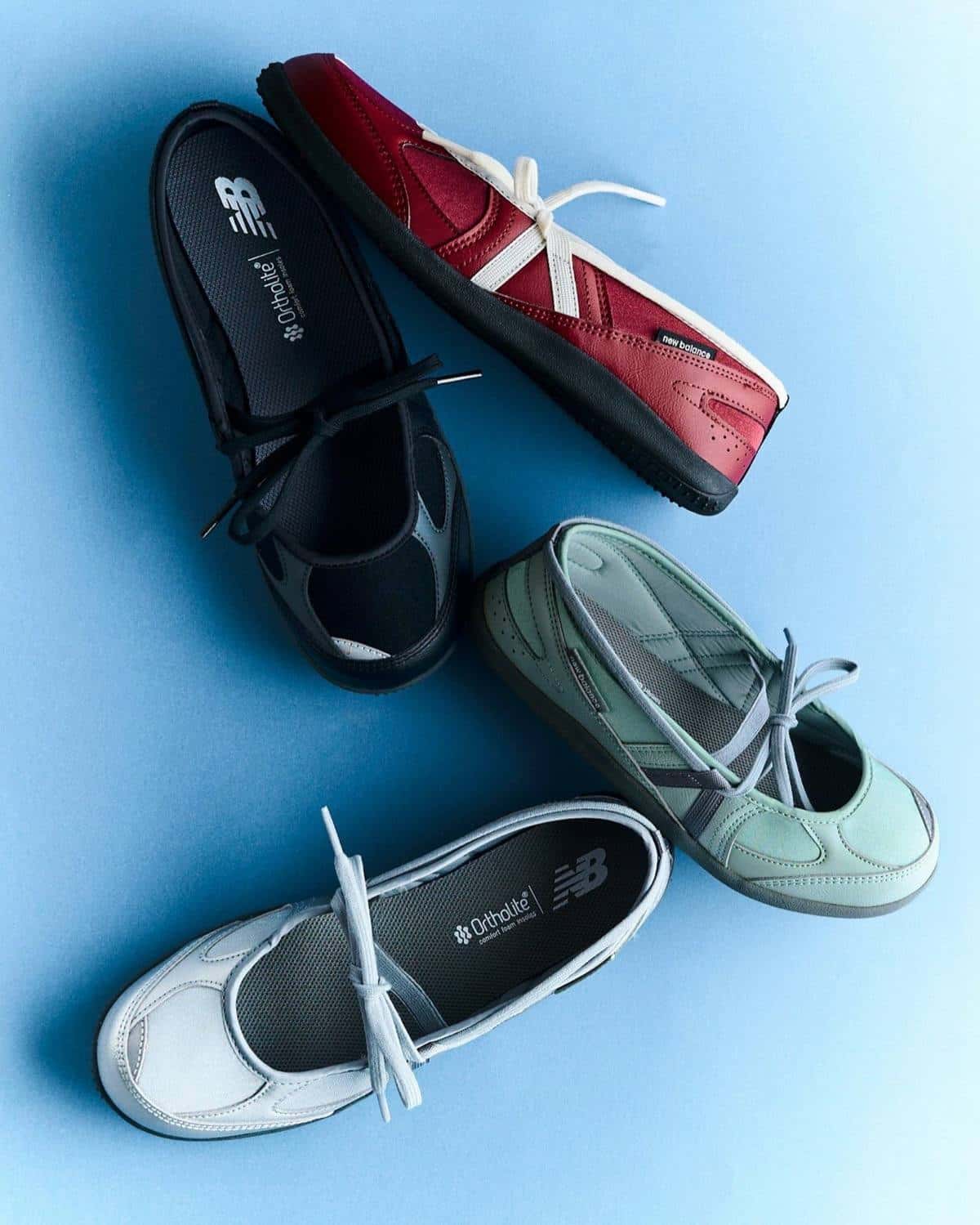 Cuatro New Balance Flat Breeze, en negro, rojo, verde menta y plateado, con cordones blancos cruzados, sobre fondo celeste