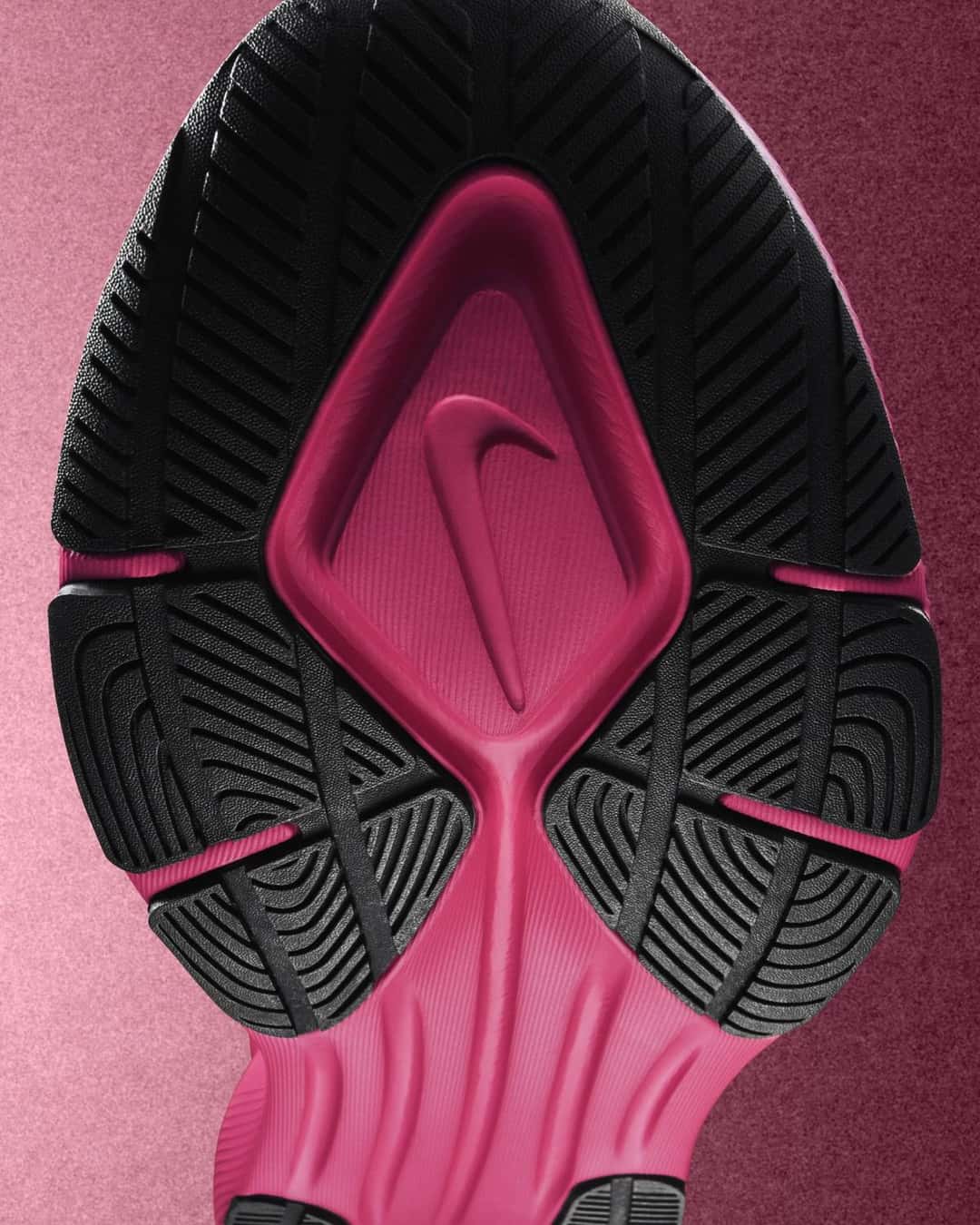 Suela de la Nike Vegam Run, con el dibujo de goma negra y rosa y una pipa grabada en el centro