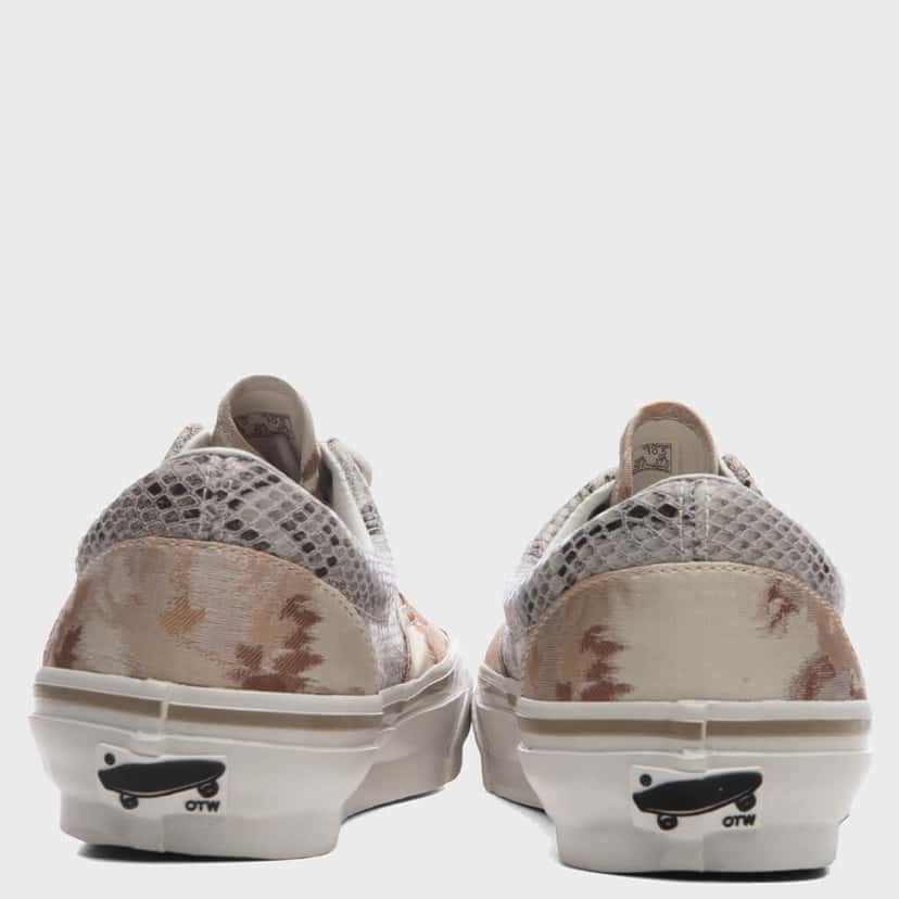 Vista trasera del par de OTW by Vans Era 95 Vibram Floral River Taupe sobre fondo gris claro, con el textil floral beige y tostado en el talón, los paneles de textura tipo red arriba y la placa con la patineta y las letras OTW en la suela