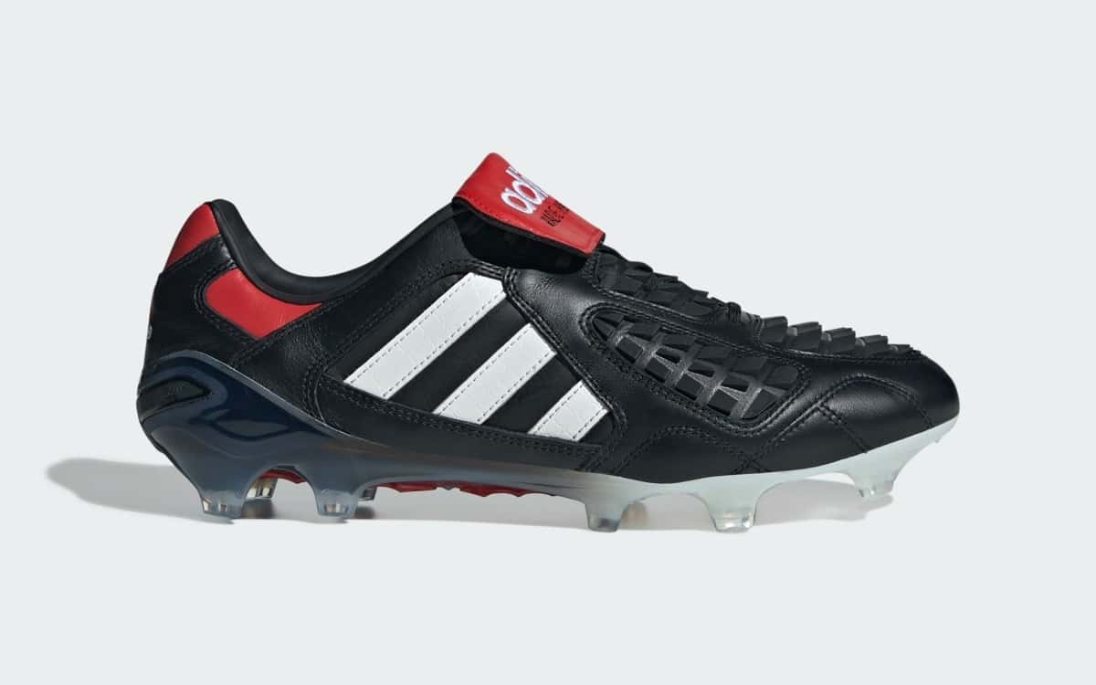 Botín adidas Predator Touch reedición 2026 en cuero negro con tres tiras blancas y lengüeta roja, de perfil sobre fondo gris claro