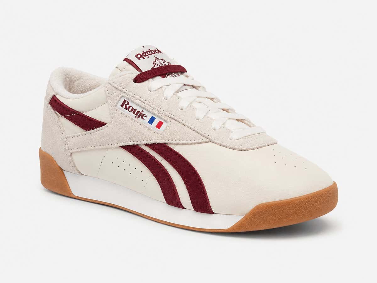 Reebok Freestyle Lo de Rouje en gamuza crema con las rayas de Reebok en bordó, etiqueta de Rouje con la bandera francesa en el costado y suela de goma marrón