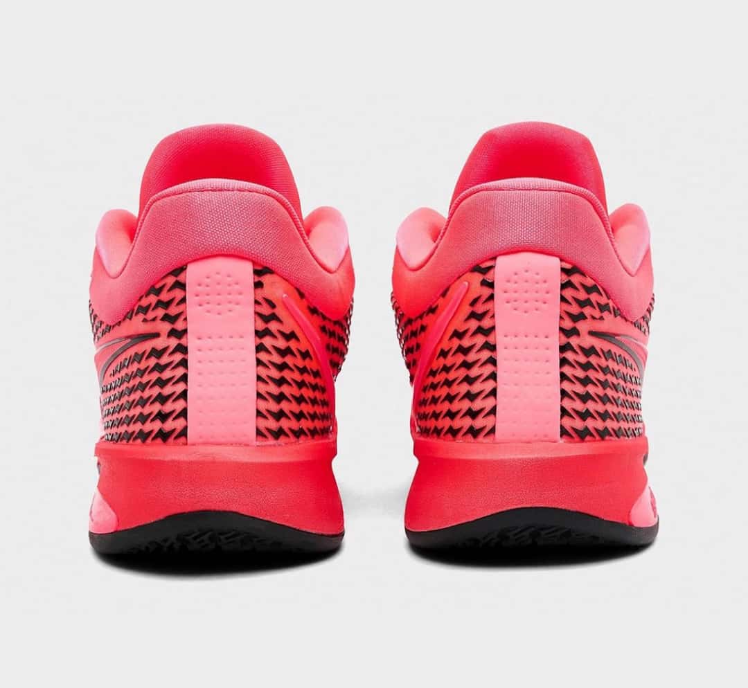Vista trasera del par Nike Sabrina 4 Light Work, con la pieza rosa perforada del talón y la malla roja con el dibujo negro repetido alrededor del contrafuerte