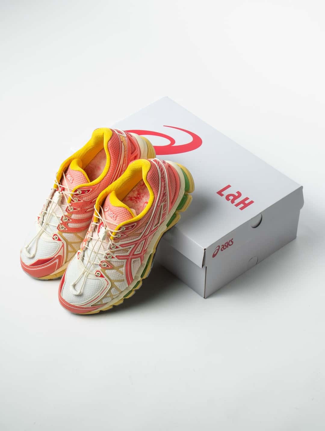 Par de SneakerLAH x ASICS GEL-KAYANO 20 Ice Kacang apoyado sobre su caja blanca con el logo de ASICS en rojo y la inscripción LAH