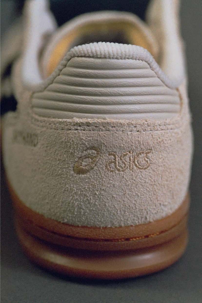 Talón de la SOSHIOTSUKI x ASICS Skyhand OG, con el logo de ASICS grabado en la gamuza crema y la suela de goma marrón
