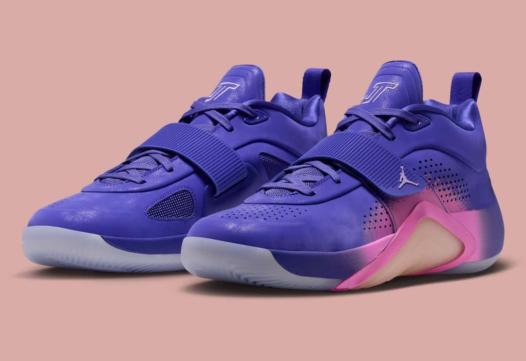 Par del Jordan Tatum 5 Sunrise en vista de tres cuartos, con upper violeta, el logo JT en la lengüeta, strap en el medio pie y degradé rosa sobre la mediasuela