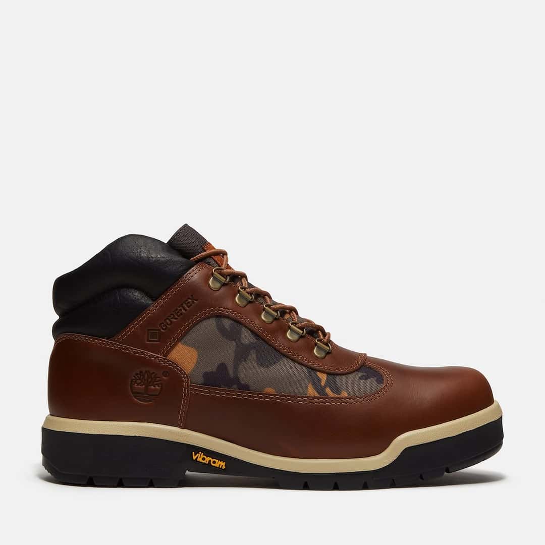 Timberland Field Boot con GORE-TEX de perfil, en cuero marrón con un panel camuflado, cuello negro acolchado y suela Vibram negra con franja crema