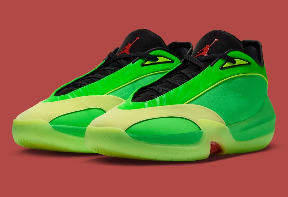 Par de Jordan Triangle Paolo Banchero sobre fondo rojo, con upper verde slime brillante, puntera y mediasuela verde lima translúcida, cuello negro y Jumpman rojo en la lengüeta